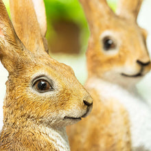 Close-up ornamental hare figurine face, tan fur with white muzzle and dark eye