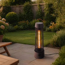 Electric patio heater lantern standing outdoors on a patio with warm internal glow
