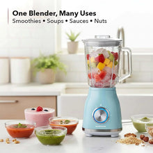 Retro smoothie blender with clear jar filled with chopped fruit; pale blue base