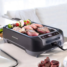Smokeless griddle grill system on countertop with lid open, cooking sausages and vegetables