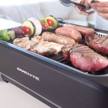Smokeless griddle grill system with hot dogs and vegetables cooking on the grill tray