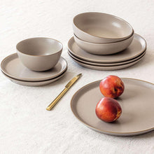 Taupe stoneware dinnerware set with layered plates and bowls, plus fruit on platter