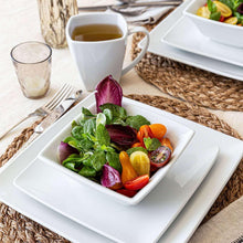 White square plate with mixed salad, with mug and bowls nearby