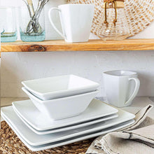 White square plates, bowls, and mug in a stacked arrangement