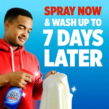 Blue-and-red laundry stain remover spray canister held in a hand