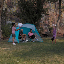Teal and gray sun shelter tent set up on grass with open front