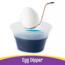Egg dipper tool for dipping eggs into dye, shown above a dye cup