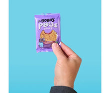 Bobo's grape PB&J oat snack pouch held in a hand