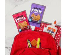 Bobo's PB&J oat snack pouches near a red pencil backpack on a tabletop