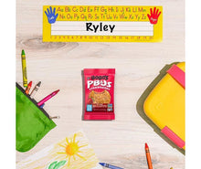 Bobo's strawberry PB&J oat snack pouch on a wood table with school supplies