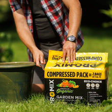 Compressed garden mix pack held in hands, yellow top and black front.