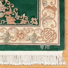 Green rug corner with cream vines and medallion motifs, finished with white fringe