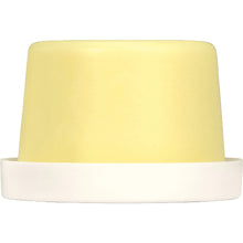 Cream-colored solid lotion puck on a white base