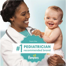 Pediatrician holding a smiling baby with wipes package graphic