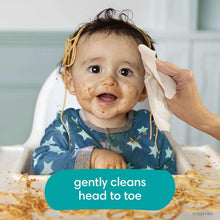 Baby wipe being used to gently clean an infant in a high chair