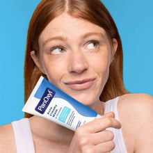 Benzoyl peroxide acne creamy wash tube held in hand, white cap, blue label