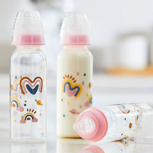 Two standing and one lying baby bottles with pink standard nipples and rainbow print