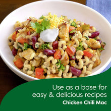 Bowl of fusilli pasta with diced vegetables, cheese sauce, and parsley garnish