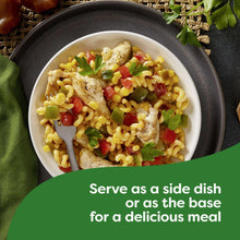 Plate of fusilli pasta with vegetables, cheese sauce, and chicken pieces
