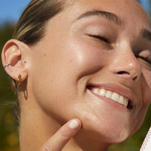 Smiling woman with an acne dot on her chin