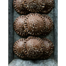 Chocolate cookie pastries sprinkled with sugar, arranged on tray
