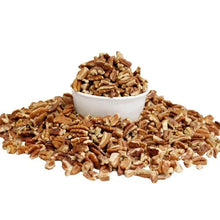 Bowl of pecan pieces with scattered chopped pecans