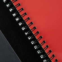 Spiral binding detail on black organizer with red inner edge