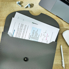 Textured gray expanding file folder holding letter-size documents with snap closure.