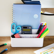White desktop organizer filled with pens, notebooks, and sticky notes