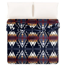 Pendleton faux fur blanket spread over a bed, with repeating navy, cream and rust triangles