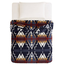 Pendleton faux fur blanket covering a bed, with navy geometric motifs and rust accents