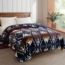 Pendleton faux fur blanket in navy with cream, rust and gold geometric patterns, draped over a bed