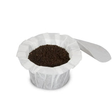White ridged paper coffee filter filled with dark grounds and a side scoop