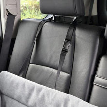 Light gray pet bed panel with black securing strap on car seat