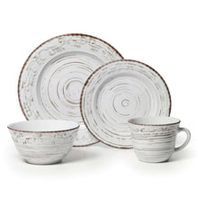 White stoneware dinnerware set with swirl-pattern plates, bowls, and mugs