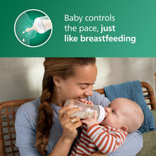 Natural glass baby bottle with white nipple held by parent during feeding