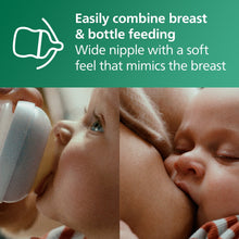 Clear glass baby bottle with wide nipple positioned at baby’s mouth