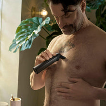Handheld precision trimmer in use on chest hair, black clipper head visible