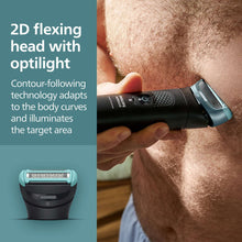 Body groomer with 2D flexing head used on chest hair area, black and teal device