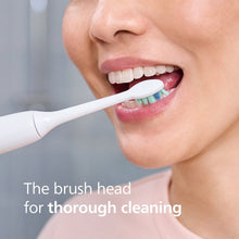 Sonicare brush head in use on teeth and lips, soft blue and green bristles
