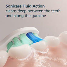 Sonicare brush head bristles in water, showing blue and green cleaning tips