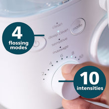 Hand adjusting the control knob on the oral irrigator base with mode settings