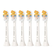 Six white Philips Sonicare replacement toothbrush heads lined up, with orange bristle accents