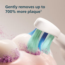 Toothbrush bristles cleaning with foamy spray on teeth and gums