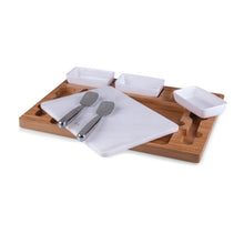 Wooden mixing tray with white board, two metal spatulas, and three condiment cups
