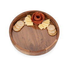 Round acacia wood serving tray with cheese, crackers, and rolled slices inside