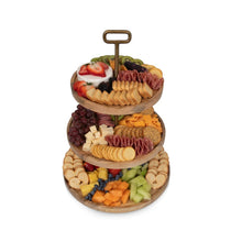 3-tier wooden serving tray with sliced fruit and cookies arranged on round tiers