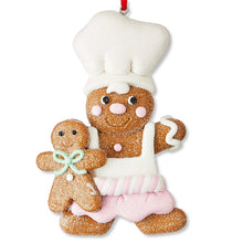 White-hatted gingerbread chef ornament with pink striped apron and gingerbread kid