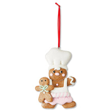 White-hatted gingerbread chef ornament with pink striped apron and red hanging string