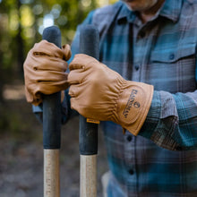 Brown leather gloves being worn, full hand coverage with snug wrist cuff